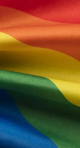 A vibrant rainbow flag with colors red, orange, yellow, green, blue, and purple.
