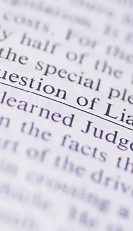 A close-up shot of a page in a book highlights the phrase "The Question of Liability."