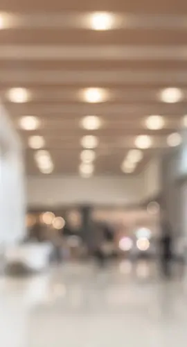 Blurred office building lobby or hotel blur background interior view toward reception hall, modern luxury lounge, white room space with blurry corridor and building glass wall