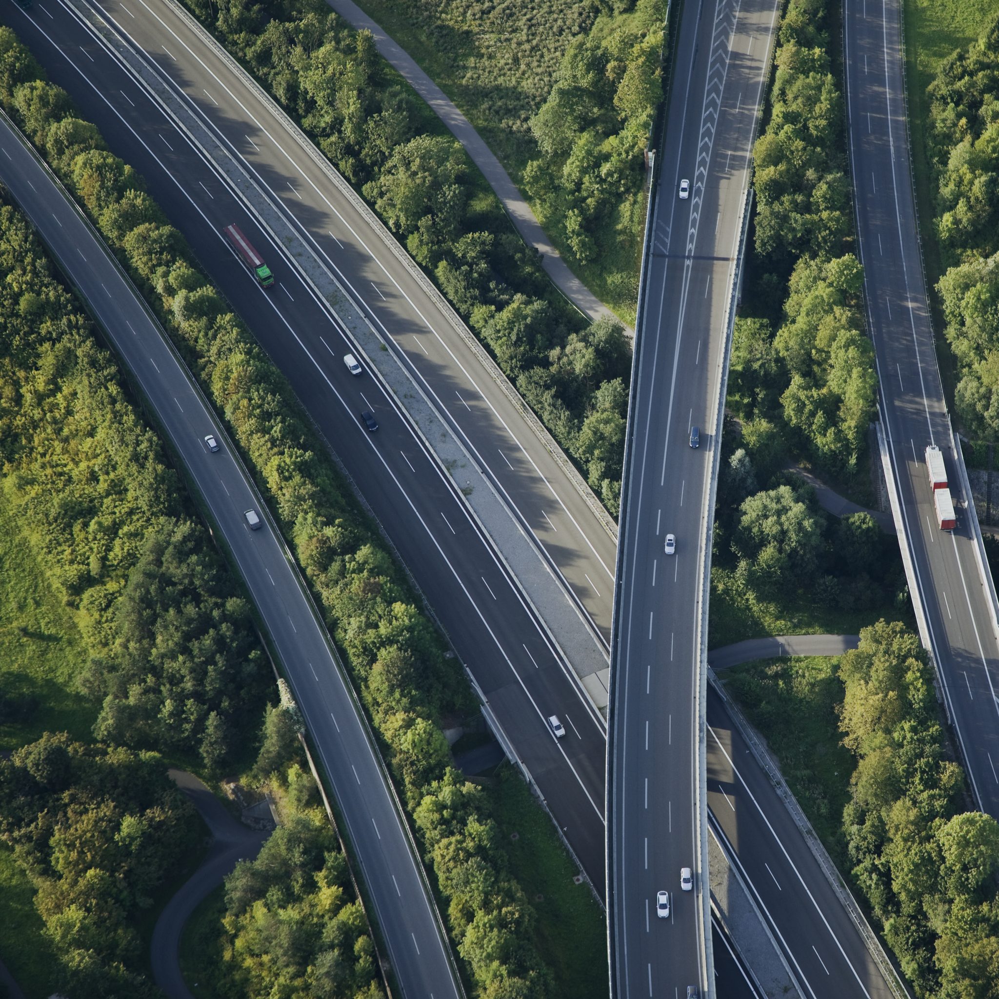 An aerial view of a highway interchange with lush greenery surrounding the roads.