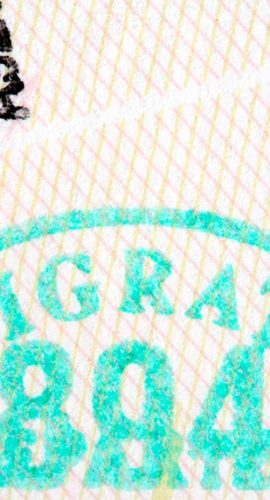 A close-up of a document shows a stamped text "IMMIGRATION" alongside other obscured text and stamp markings.