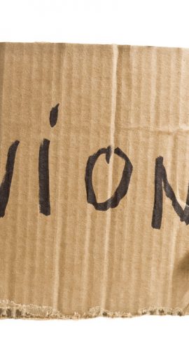A person is holding a cardboard sign with the word "union" written on it in black marker.