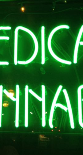 A glowing neon sign reads "MEDICAL CANNABIS" in bright green letters.