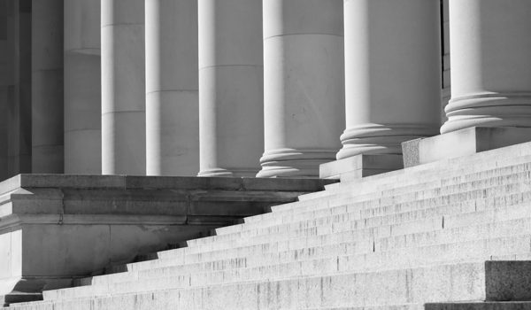 black and white image of government building pillars