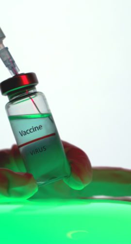 Person aspirating the vaccine from the vial