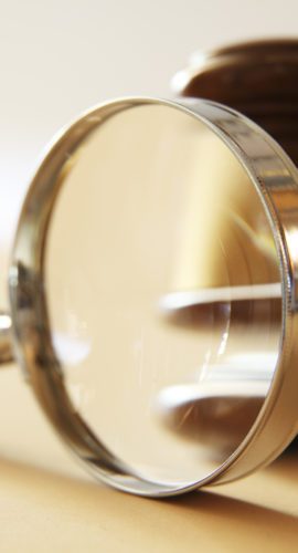 A gavel seen through a magnifying glass.  Photographed with a very shallow depth of field.