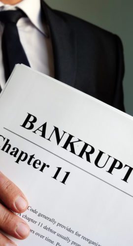 Man holds Bankruptcy Chapter 11 agreement documents.
