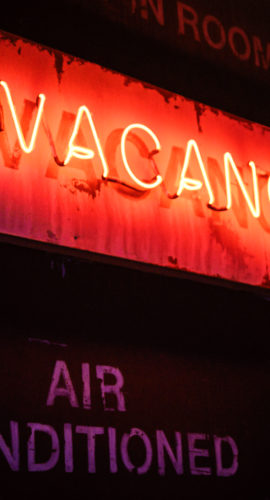 An illuminated neon "vacancy" sign.
