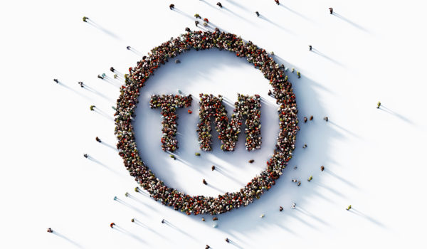 Human crowd forming trademark symbol on white background. Horizontal composition with copy space.