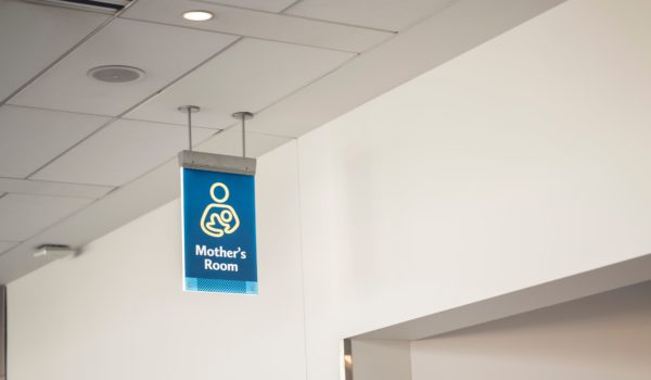 A low angle shot of a blue mother's room sign inside an airport